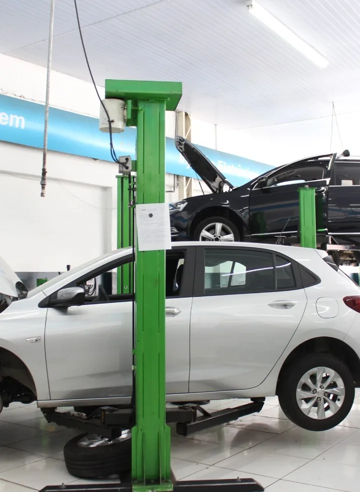 Elevador e veículos na área de manutenção da Premium Center Car