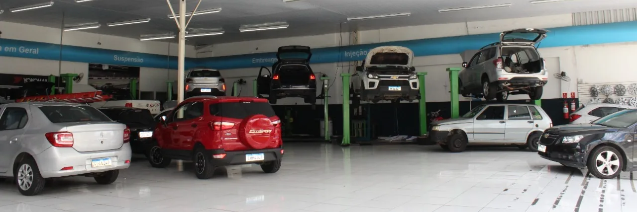 Vista interna da Premium Center Car com veículos e elevadores